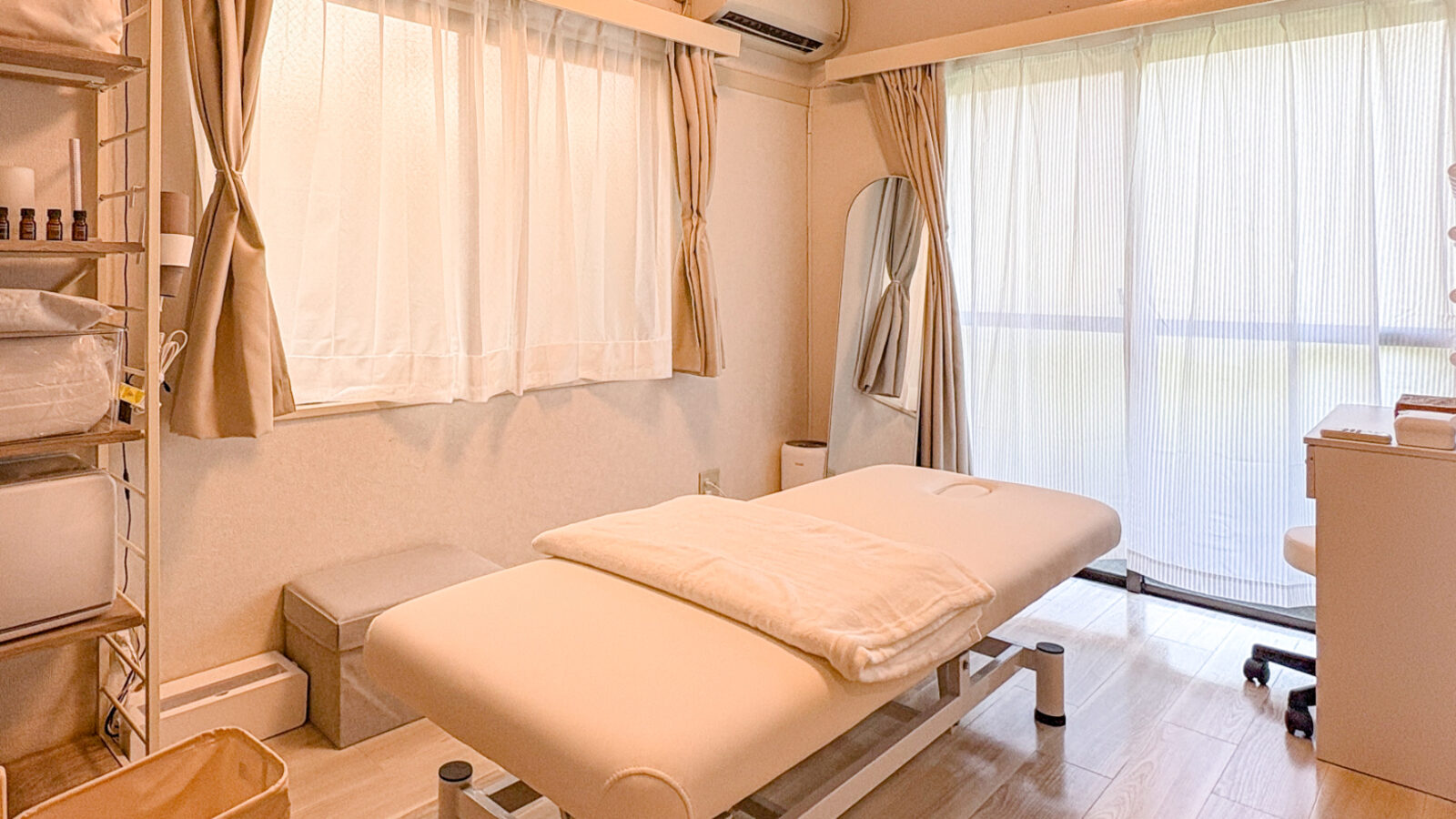 Airy Salon 東白楽の施術室全景。電動昇降ベッド・女優ミラー・自然木の家具でととのえた完全個室。